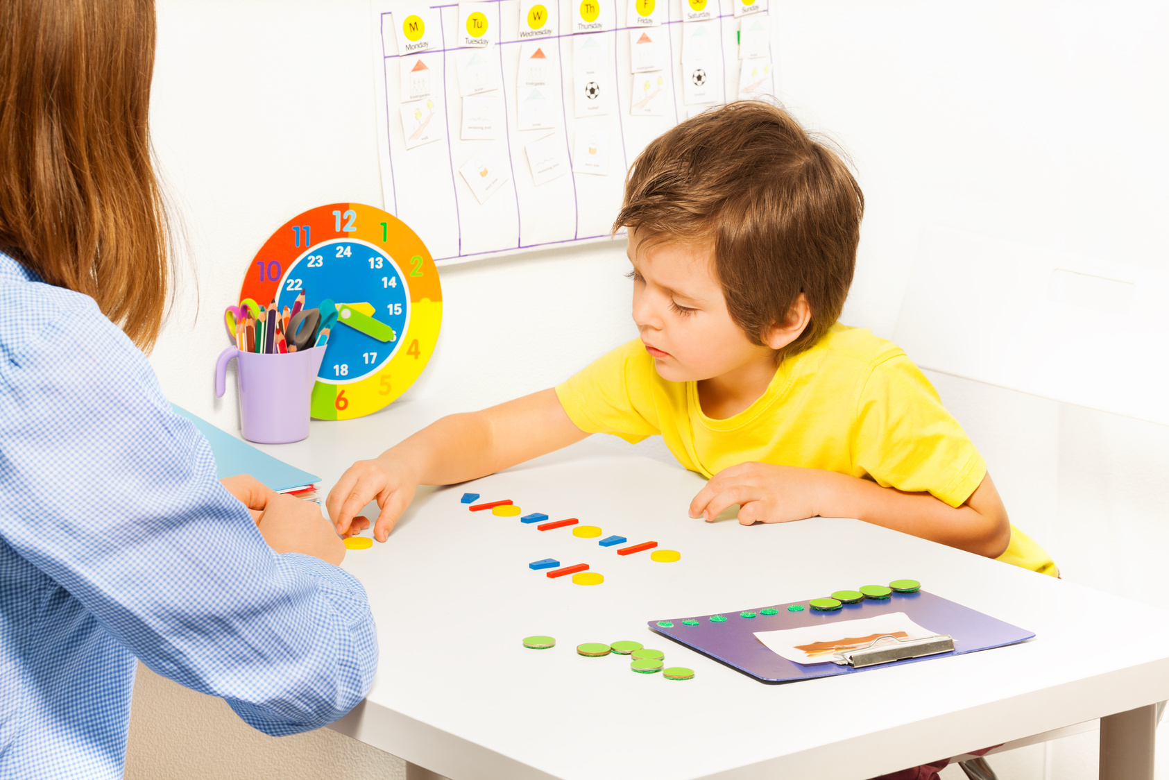 Concentrated Boy Putts Colorful Coins during ABA